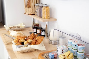 A breakfast buffet with pastries, jams, and dairy products.