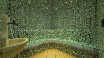Bathroom features a mosaic tile design with a wave-like pattern, stone sink, and modern lighting.