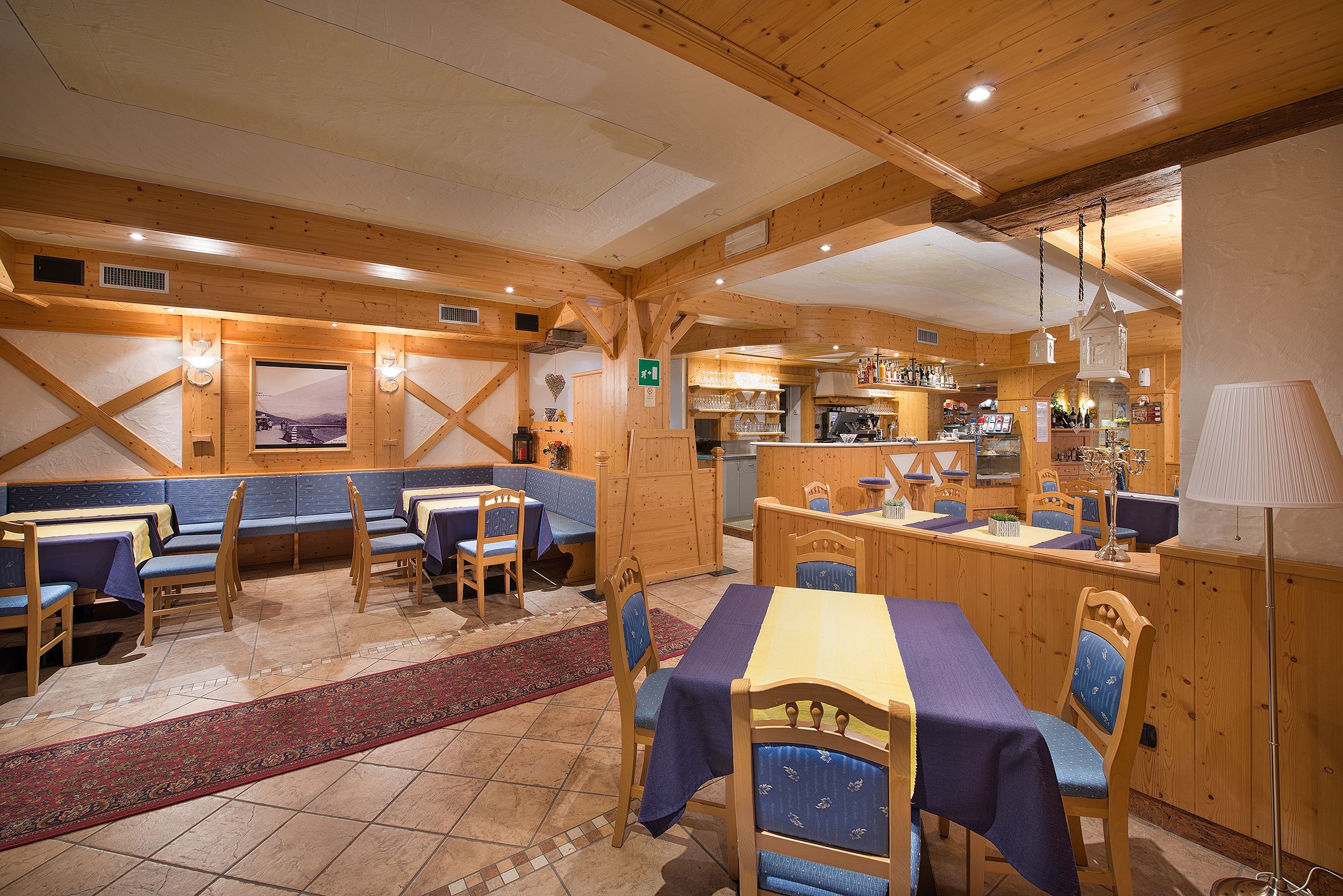 Ein gemütliches Restaurant mit Holzeinrichtung, einer Bar und Blick auf die Berge.