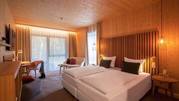 Een hotelkamer met twee bedden, een bureau, een stoel en een televisie.