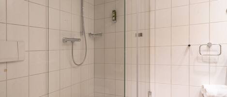 Un baño moderno con ducha de vidrio, inodoro y lavabo.