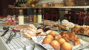 A buffet table with various pastries, fruits, and beverages. - Arriadh (Córdoba)