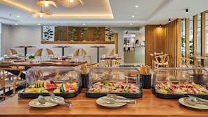 A buffet setup with various food items and utensils. - Lotus Rise Hotel (Hersonissos)