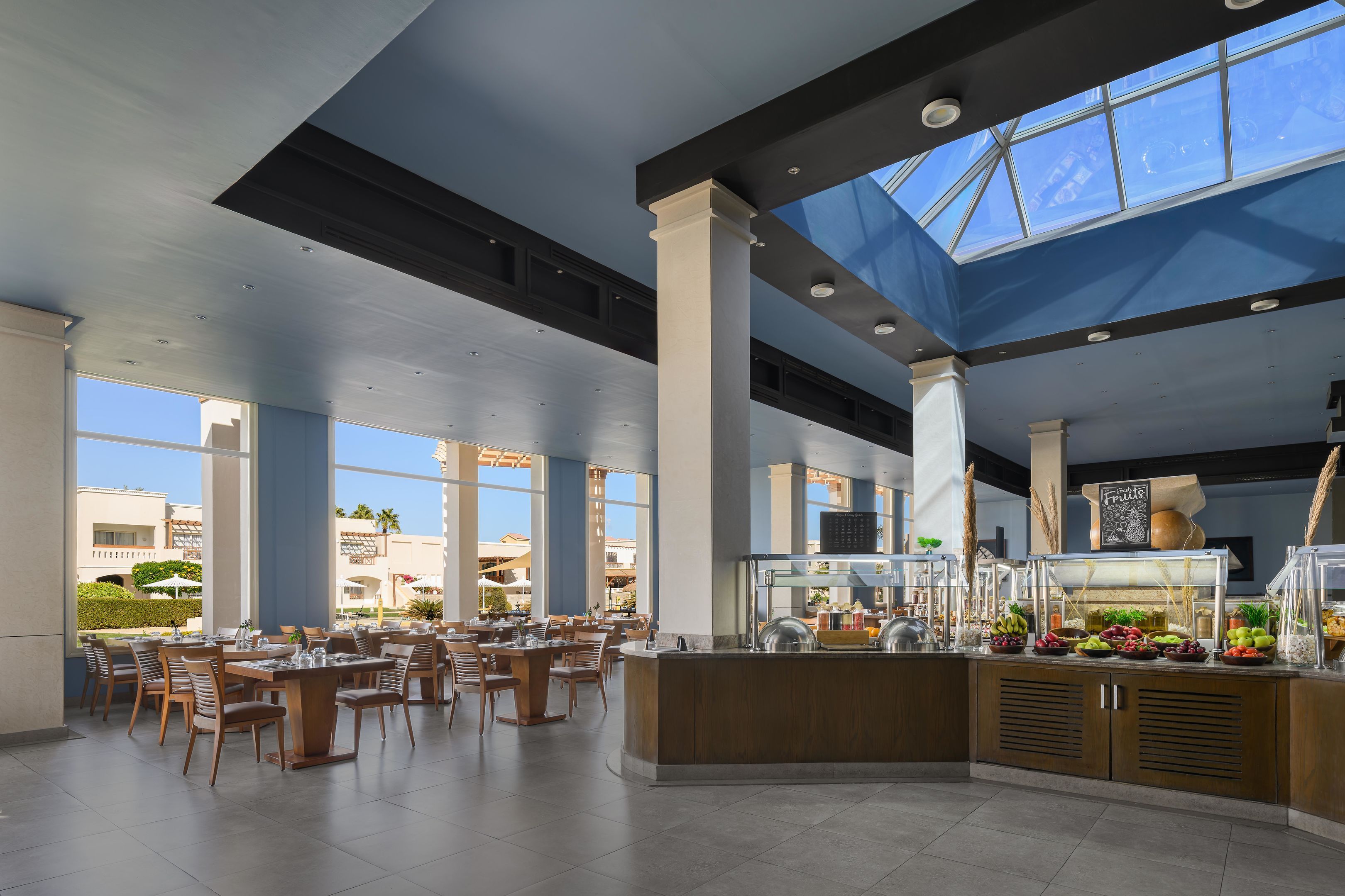 Zona de dinar espaiosa amb sostres alts, grans finestres i una barra de buffet central.