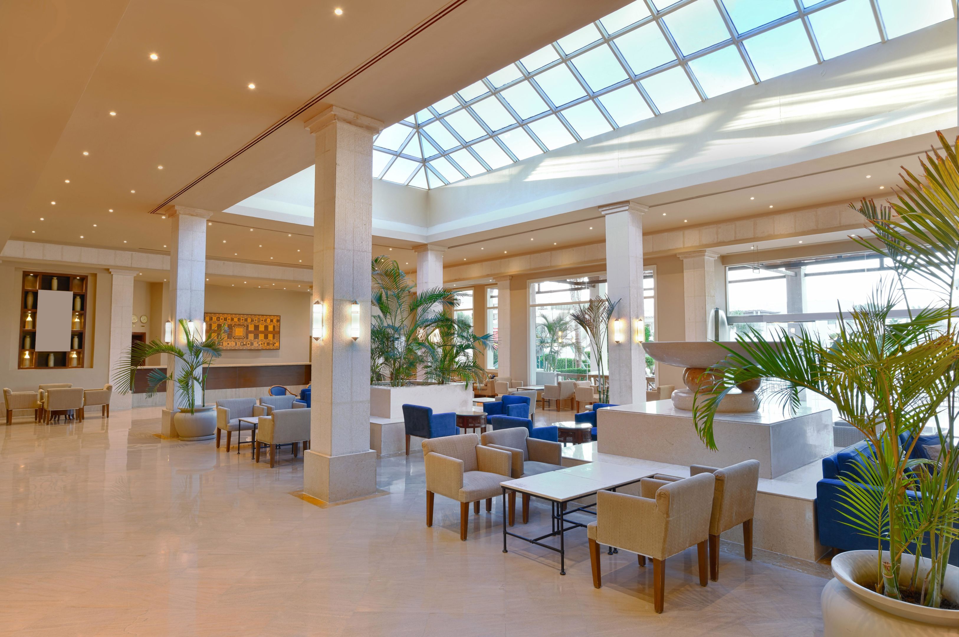 A spacious lobby with a high ceiling, large windows, and a variety of seating arrangements.