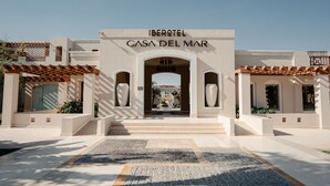 A entrada do Iberotel Casa del Mar, com vista clara da fachada do edifício, incluindo o nome e o arco de entrada.