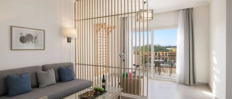 A modern living room with a sofa, coffee table, and a view of the outdoors.