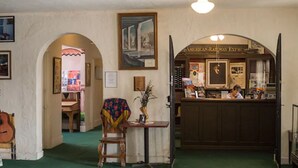 A room with a wooden chair, a table with a vase, a framed picture on the wall, and a counter with a sign reading "AMERICAN RAILWAY EXPRESS". - Amargosa Opera House (Death Valley)