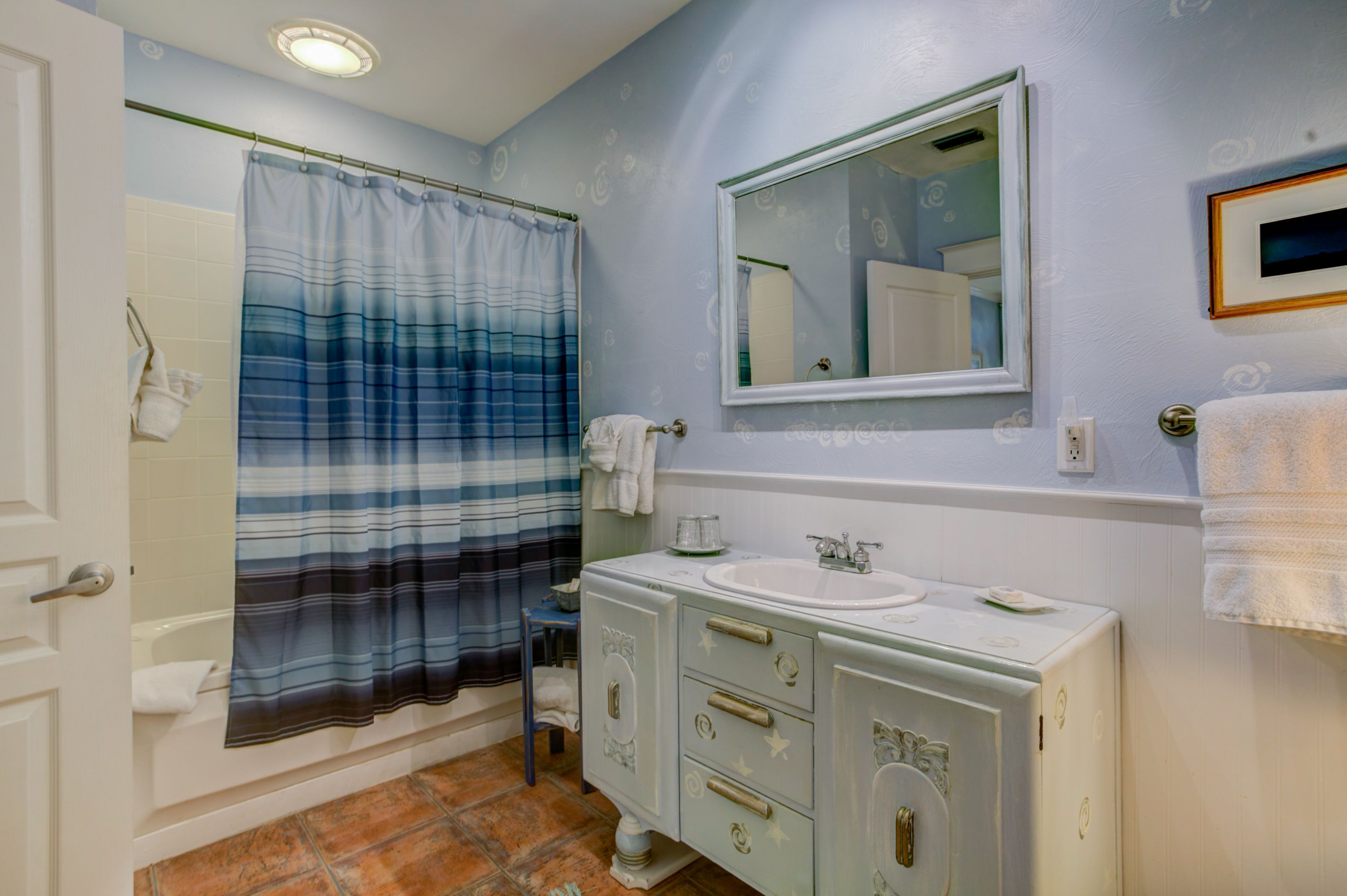 Une salle de bain avec une baignoire, un lavabo et un meuble-lavabo avec des tiroirs.