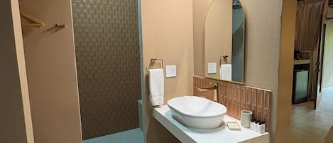 Uma casa de banho moderna com uma pia grande, um espelho e zona de duche.