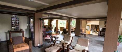A spacious indoor area with wicker furniture and a ceiling fan.