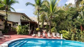 Una piscina al aire libre, sombrillas, tumbonas