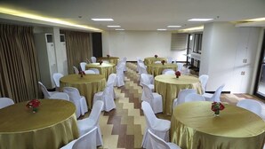 A conference room with multiple round tables, each with a gold tablecloth and white chairs. - Century Plaza Hotel (Cebu City)