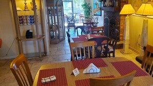Un comedor con una mesa preparada para dos personas, sillas y una lámpara.