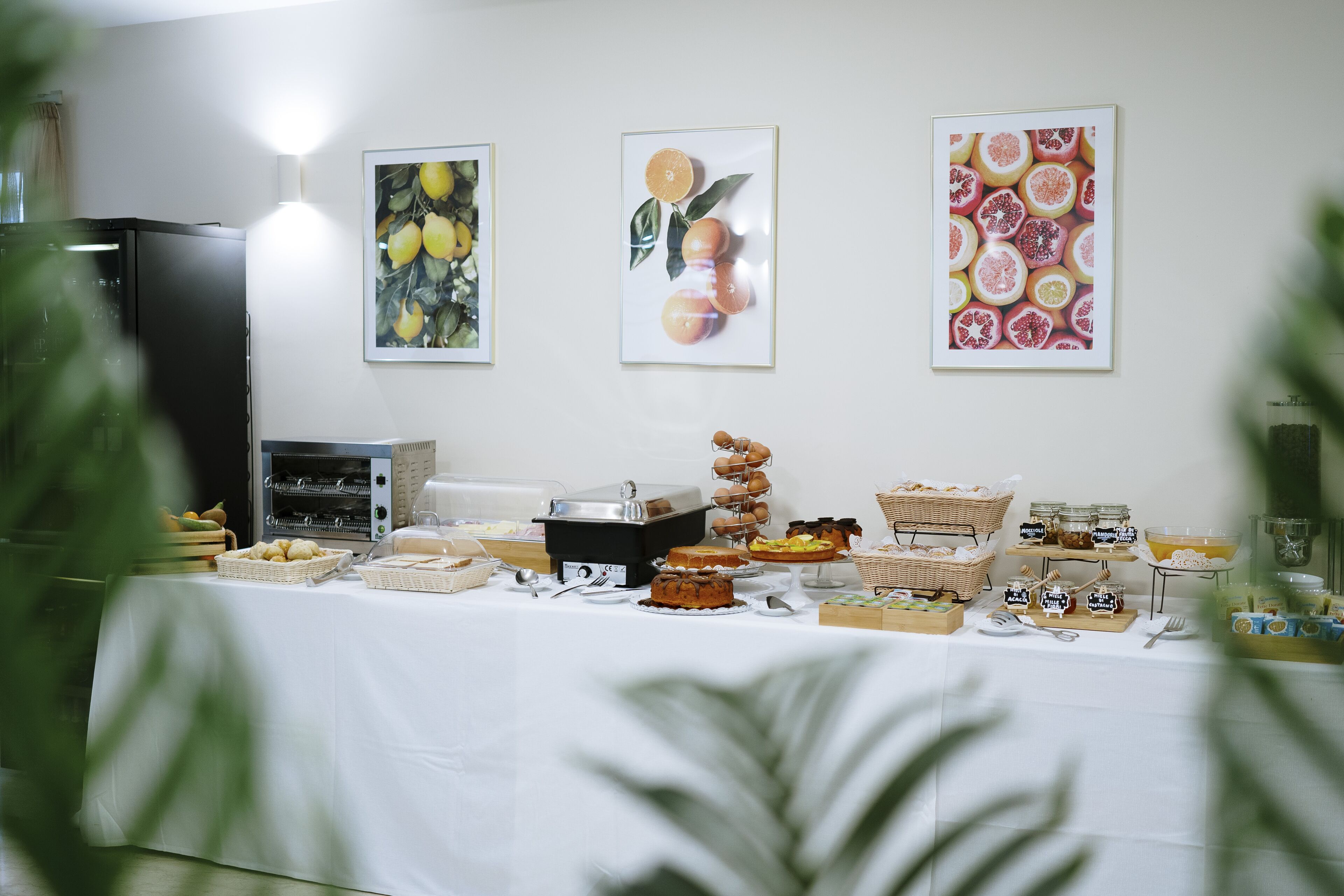 Una mesa de bufé con diversos alimentos y un refrigerador al fondo.