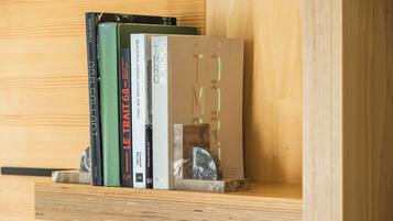 Una estantería de madera con libros y una escultura de mármol.
