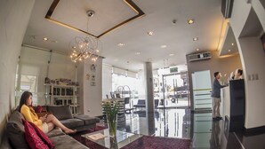 A modern hotel lobby with a reception desk, seating area, and a glass partition. - Allpa Hotel & Suites (Lima)