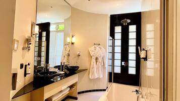 Un baño moderno con un espejo grande, una bañera y un lavabo con tocador.