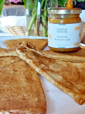 A plate of crepes with a jar of caramel sauce.