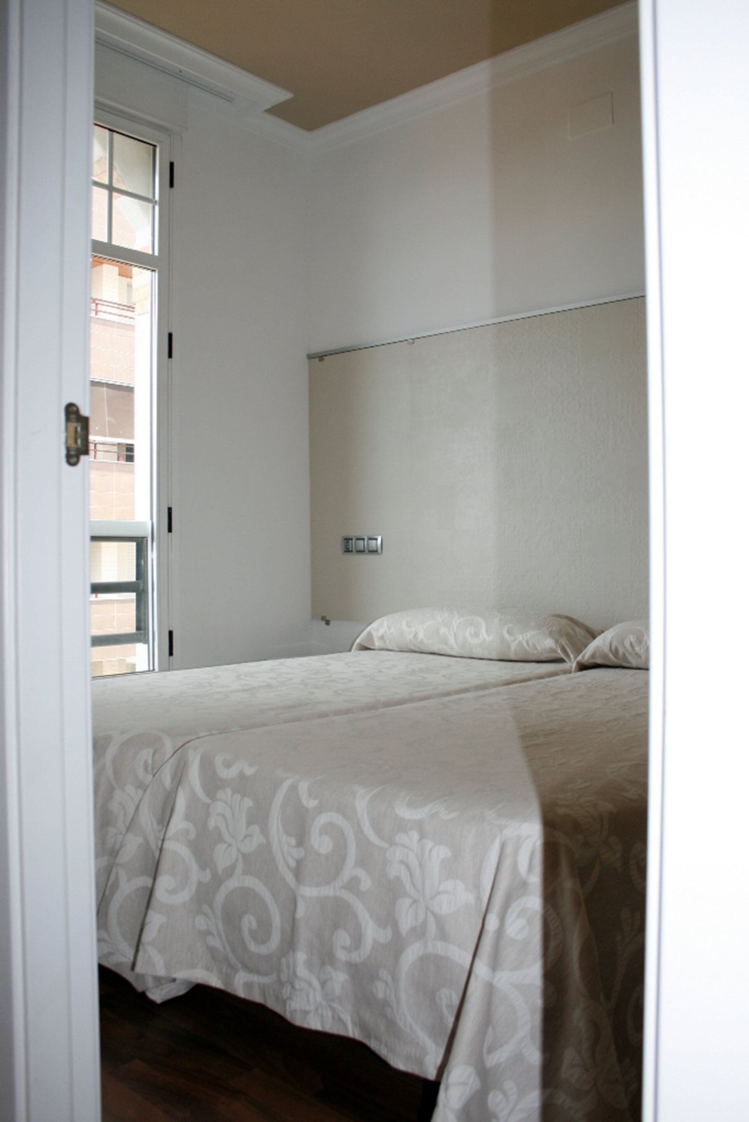 Une chambre à coucher avec un lit, une fenêtre et une porte.