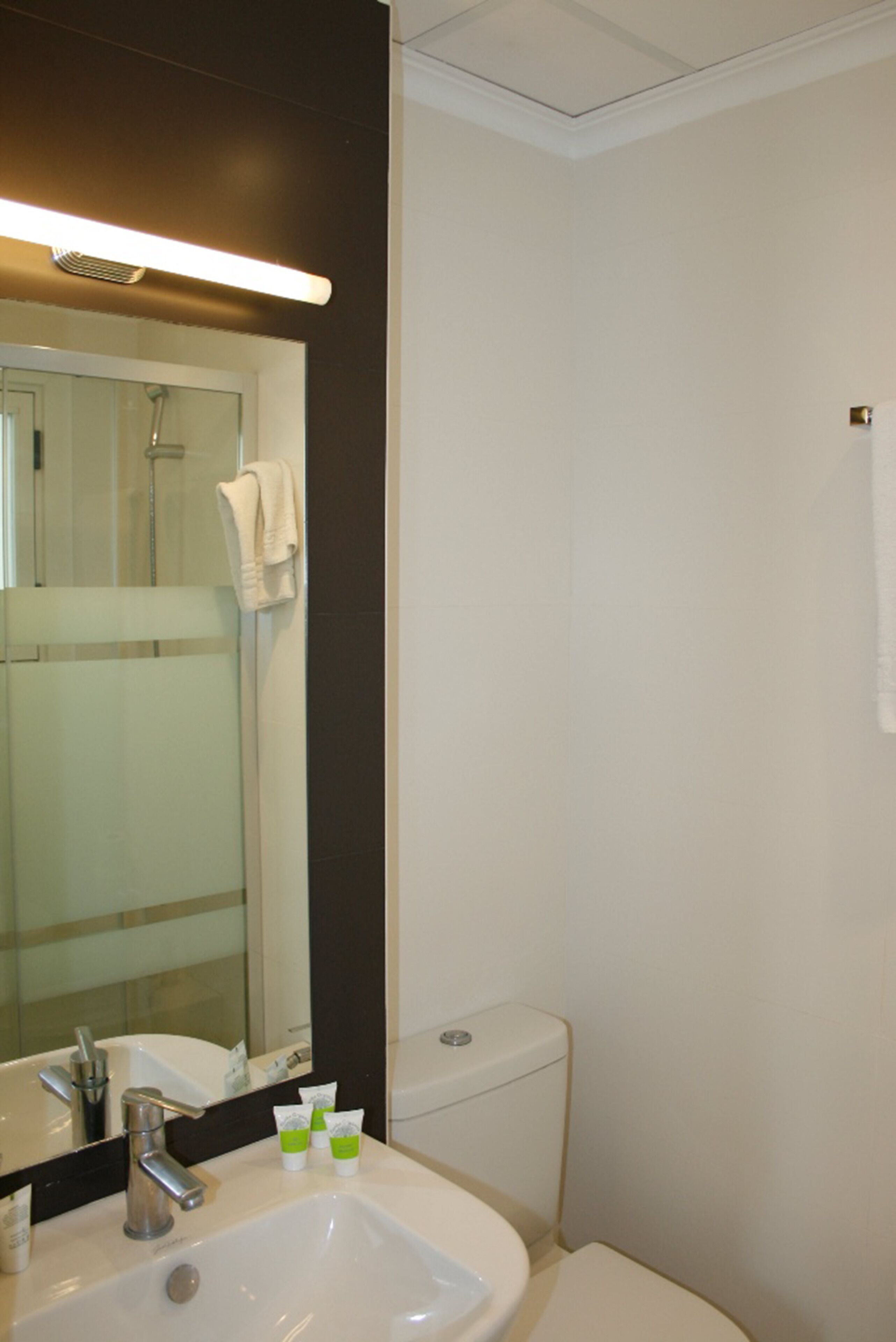 Un bagno con lavandino, specchio e WC.