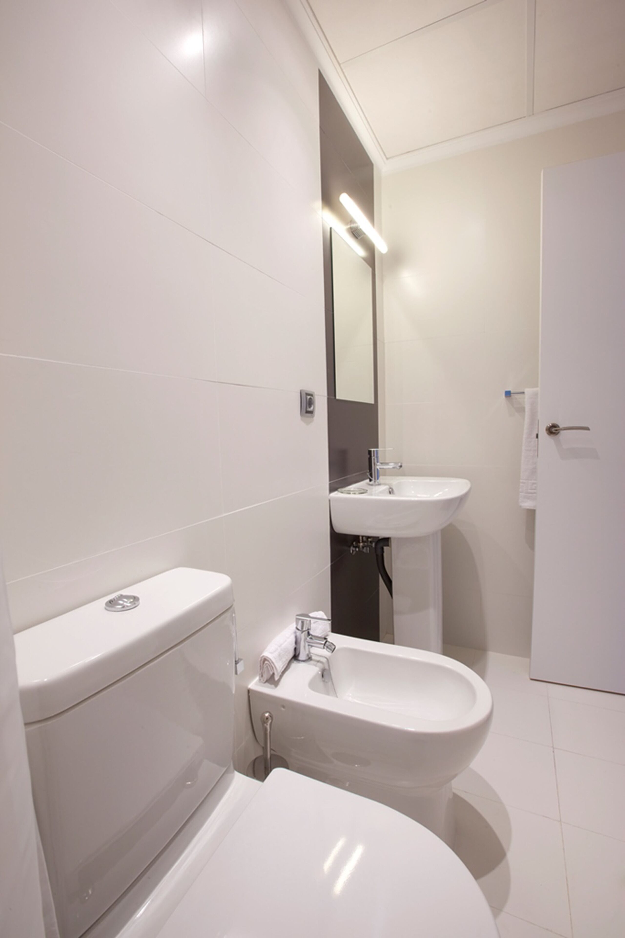 Ein modernes Badezimmer mit Toilette, Bidet und Waschbecken.