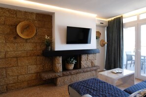 Appartement Deluxe, 1 grand lit et 1 canapé-lit, vue mer | Coin séjour | Télévision