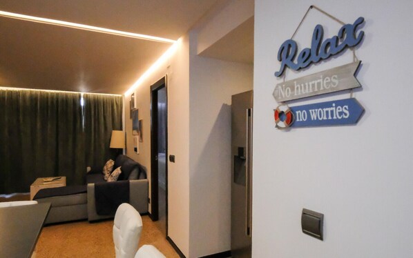 Una habitación de hotel con una cama, un escritorio, una silla y un cartel en la pared que dice "Relax No hurries No worries".