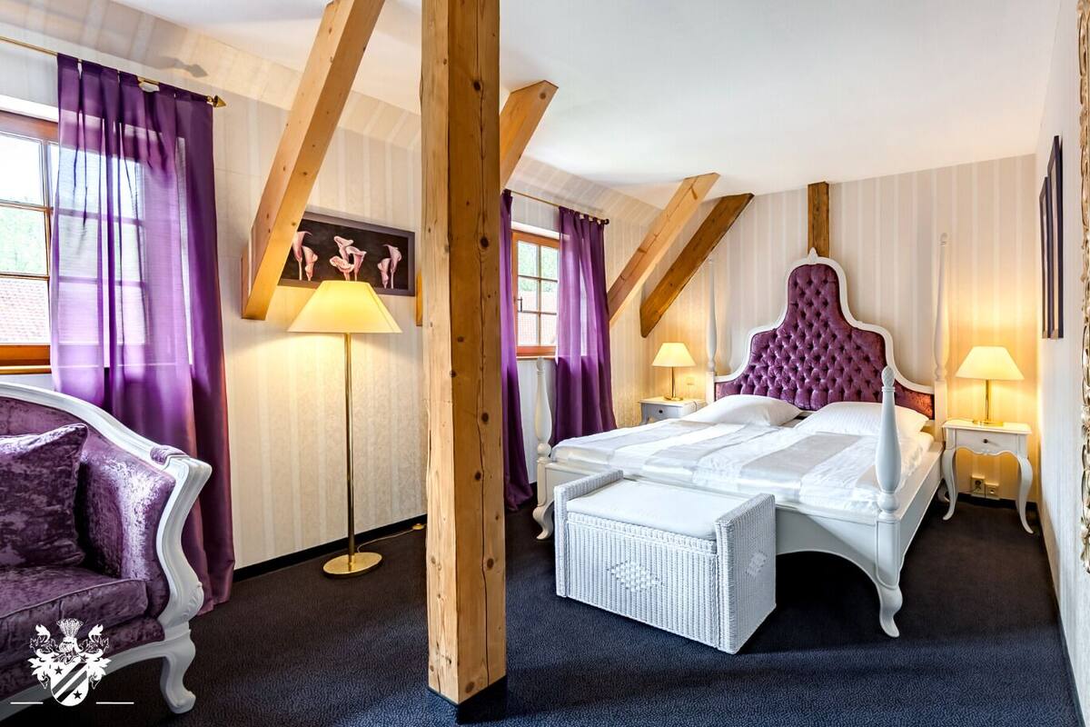 Une chambre à coucher avec un lit, une chaise et une lampe sur pied.