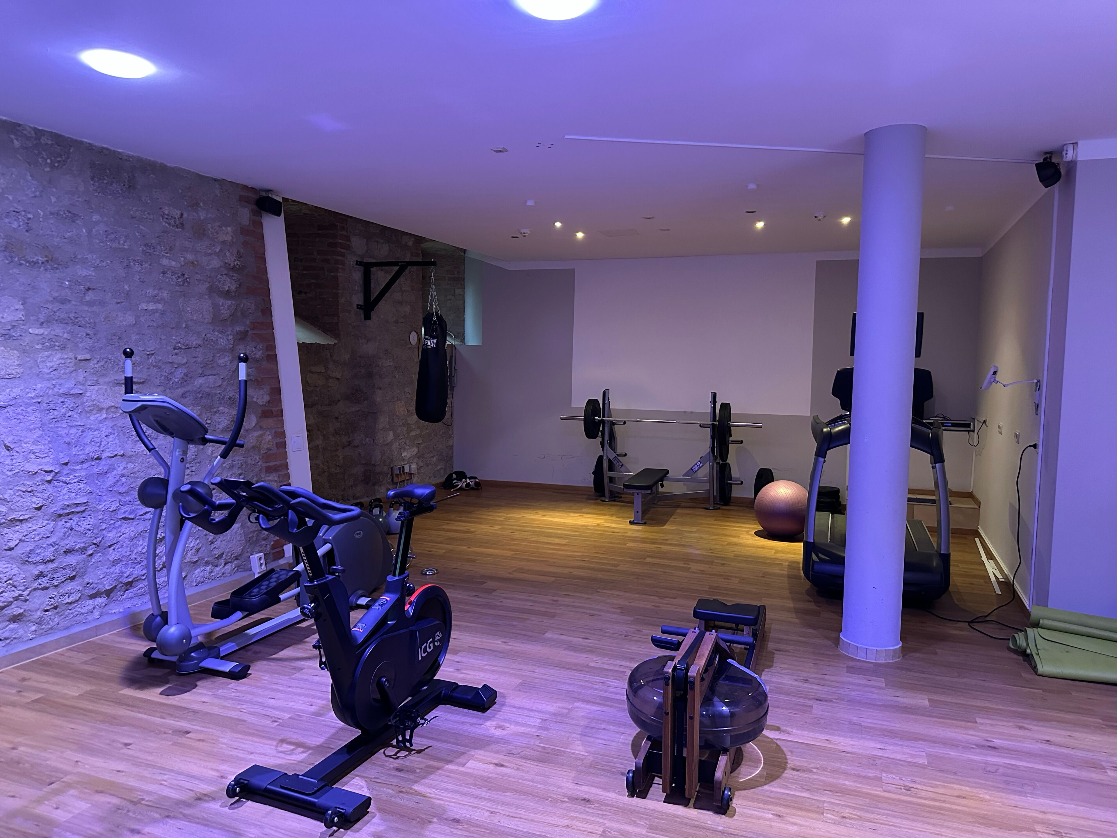 A gym with various exercise equipment including treadmills, an elliptical, and a rowing machine.