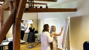 Une pièce avec des poutres apparentes, un tableau blanc et un écran de projection.