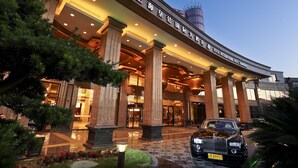 The entrance of the Royal International Hotel Shanghai with a grand facade, large columns, and a well-lit entrance. - Royal International Hotel (Shanghai)
