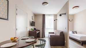 Un espacio habitable pequeño con comedor, sofá y cama.