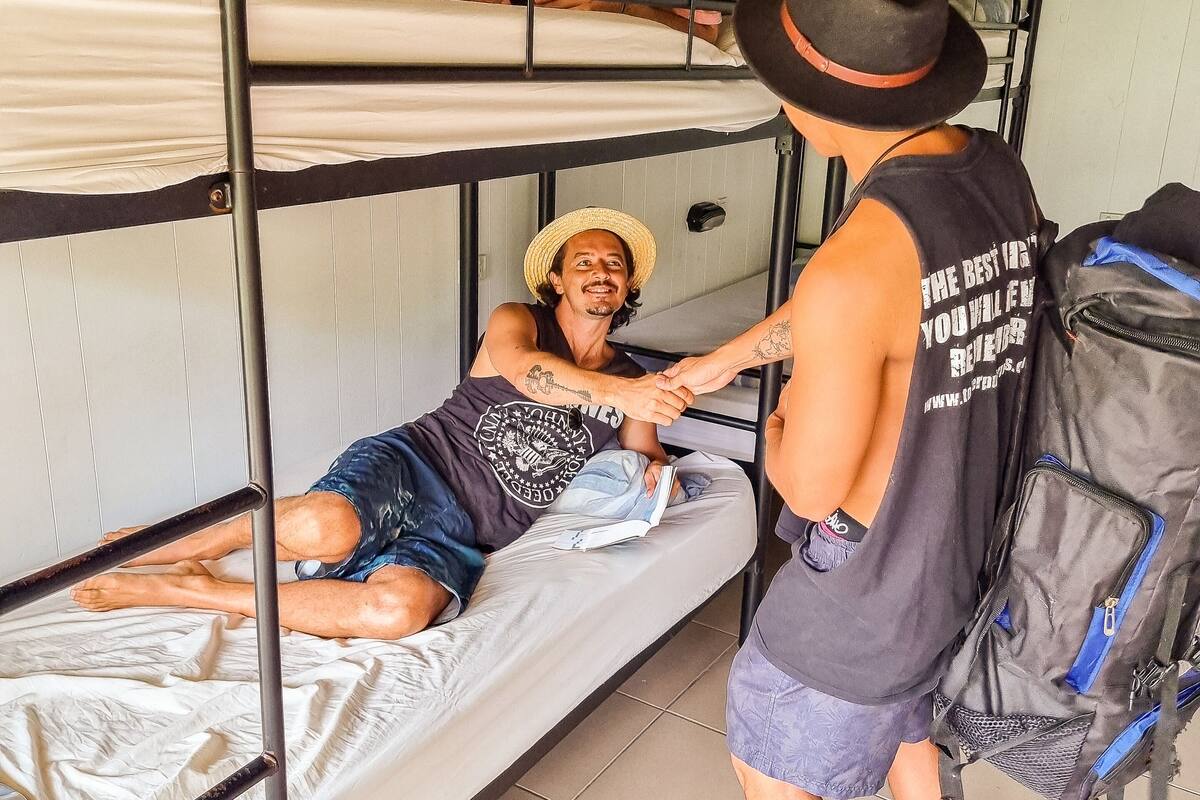 A bunk bed room with two people, one on the top bunk and one on the bottom.
