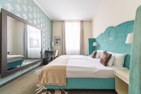 A hotel room with a large bed, a mirror, a desk, and a window with curtains. - La Prima Fashion Hotel (Budapest)