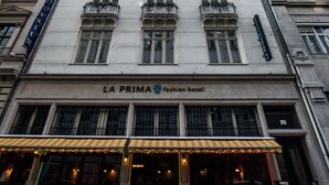 A historic building with a sign reading "LA PRIMA Fashion Hotel." It features classical architecture with ornate details and large windows. - La Prima Fashion Hotel (Budapest)