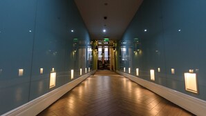A corridor with glass walls, wooden flooring, and recessed lighting. - La Prima Fashion Hotel (Budapest)