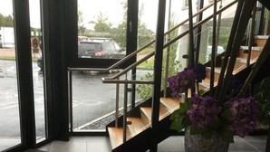 A hotel entrance with a purple mat reading "Ballygunge Hotel" and a staircase leading to the upper floor.