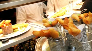 A buffet table with various food items, including fried items and a plate with a lemon wedge.