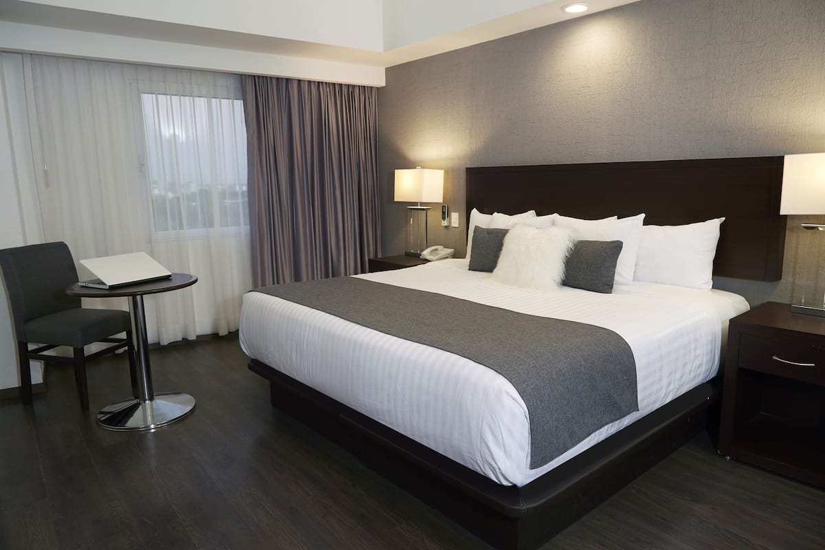 Una habitación de hotel con una cama grande, un escritorio y una silla.