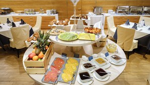 A buffet setup with various food items and serving utensils.