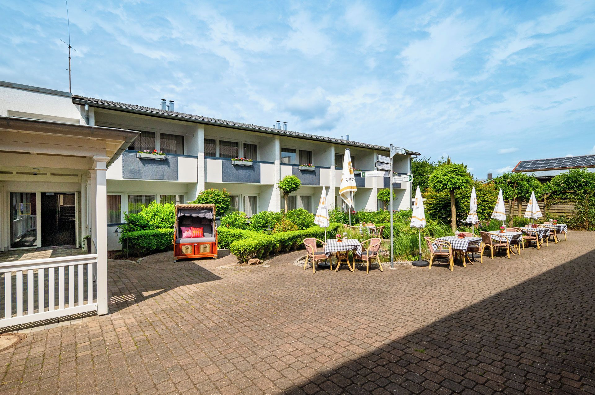 A hotel with outdoor seating and a covered seating area.