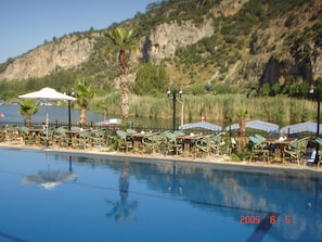 Una piscina al aire libre, sombrillas, tumbonas