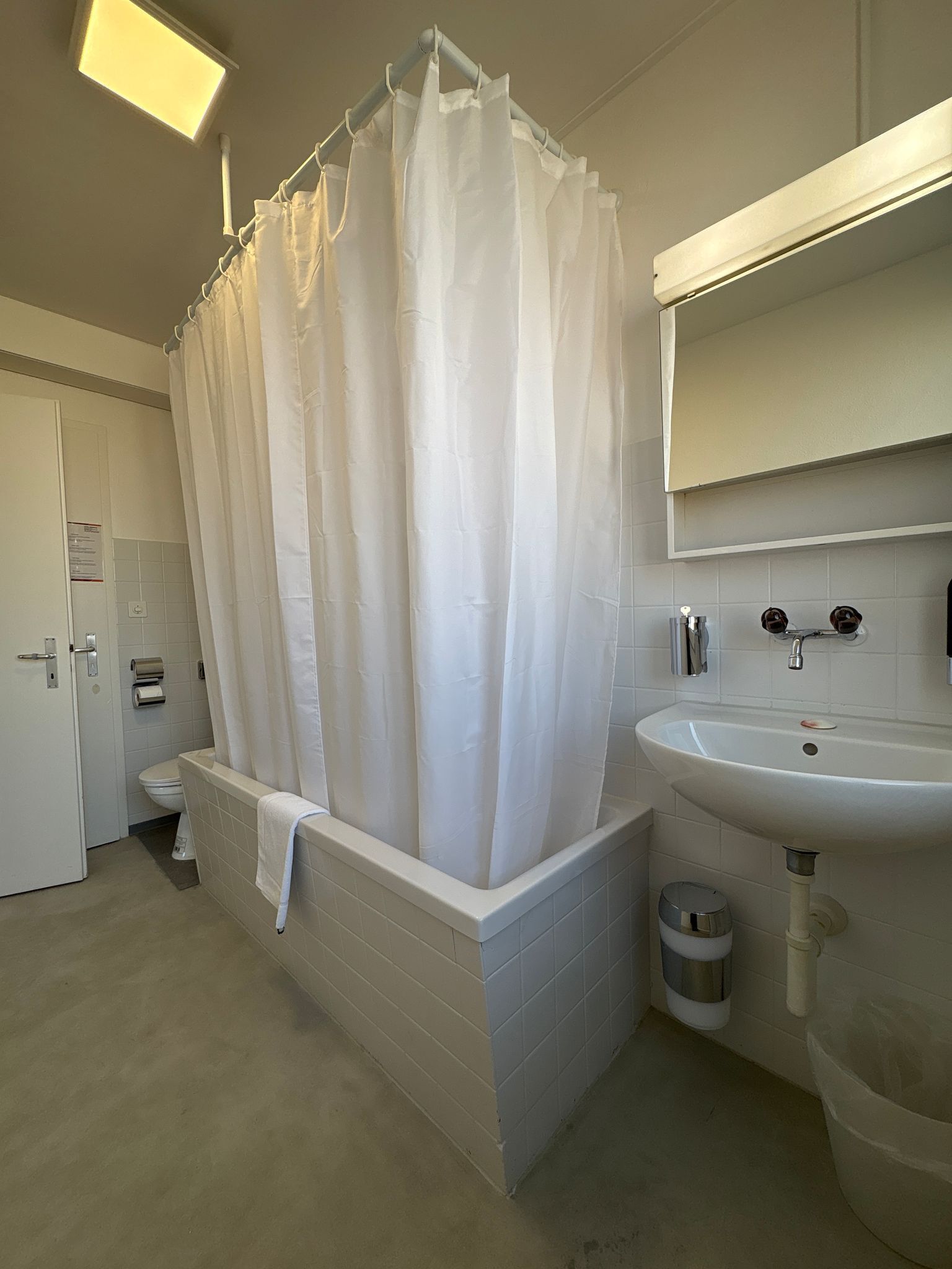 A modern bathroom with a bathtub, a sink, and a toilet.