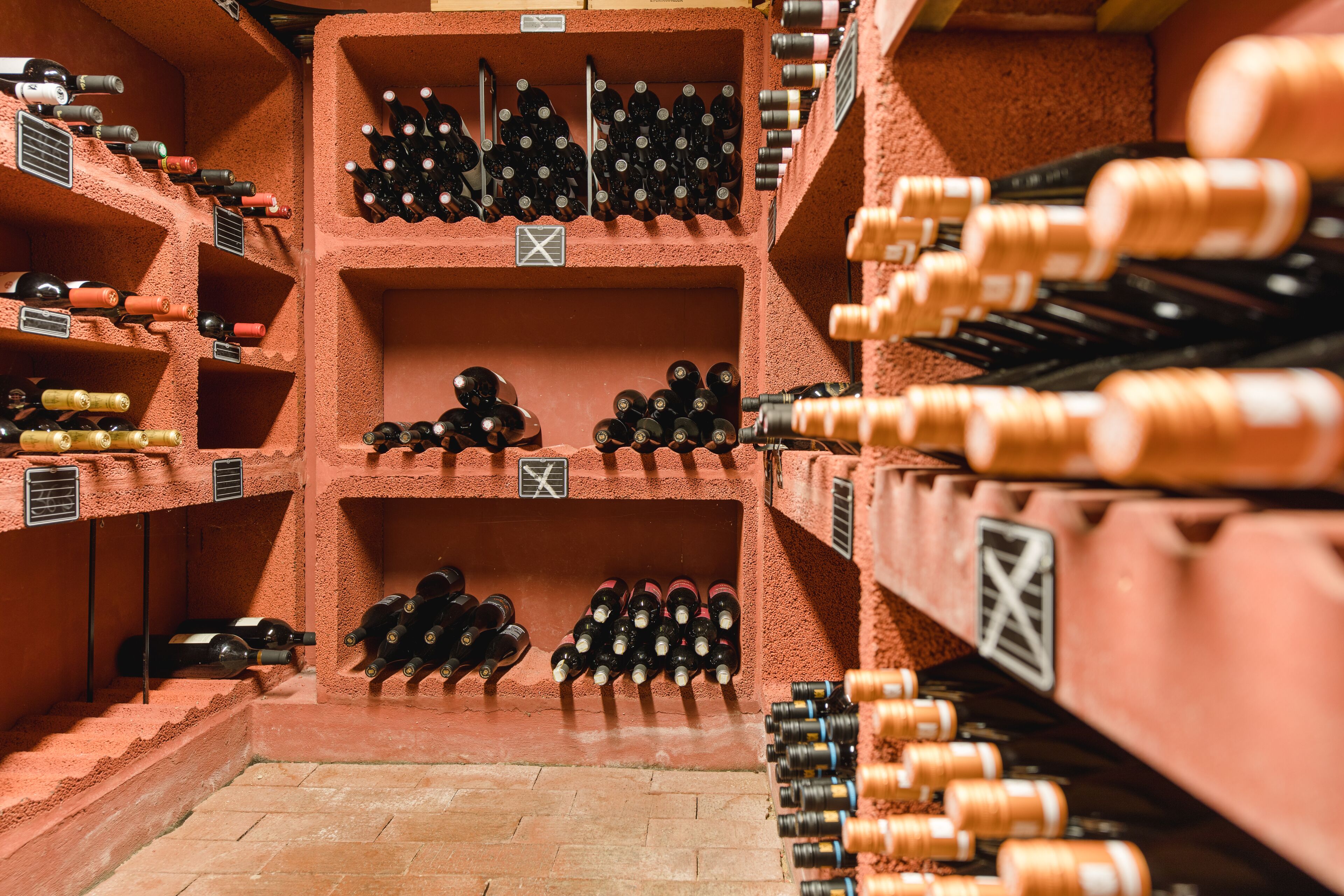 A wine cellar with multiple shelves filled with wine bottles.