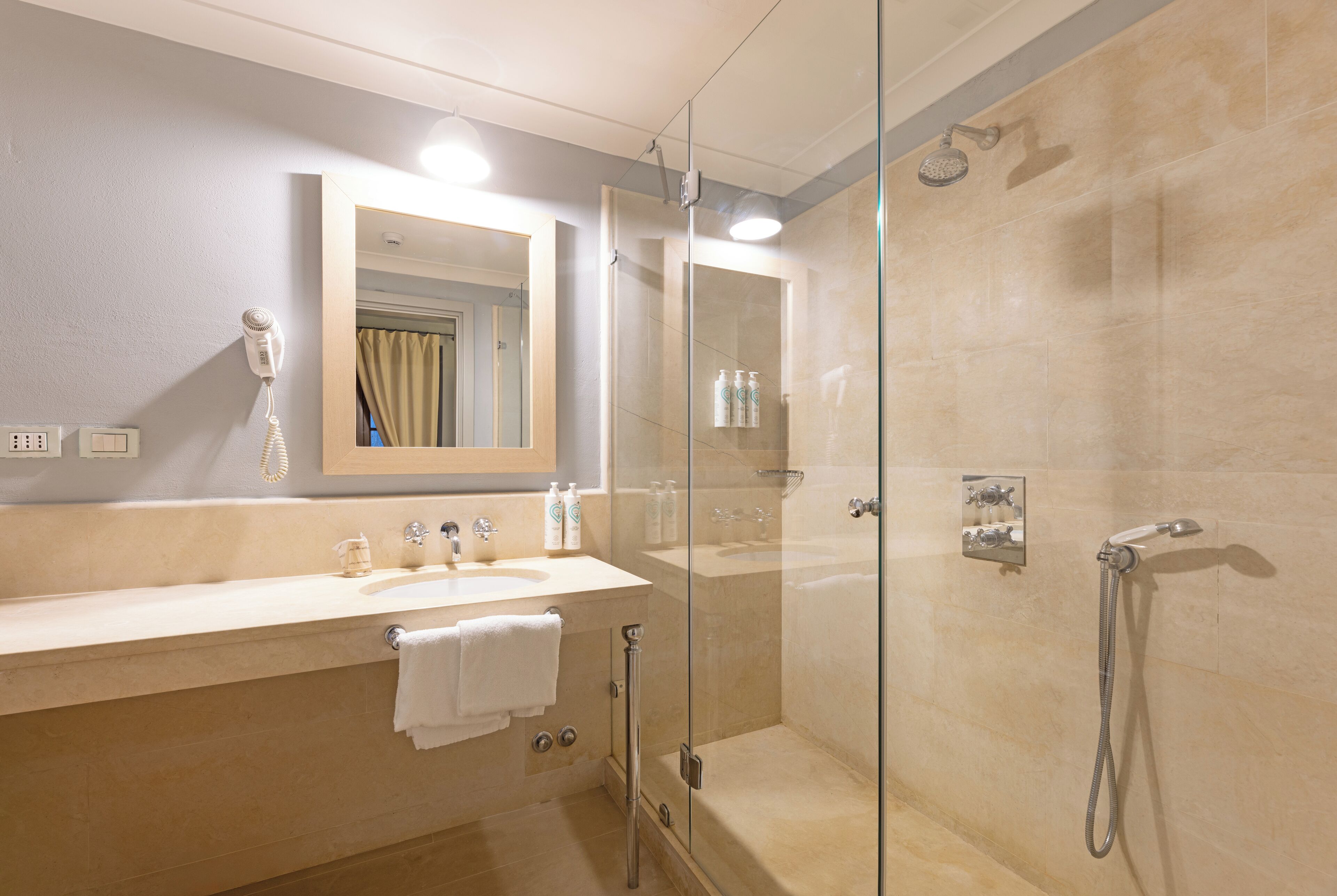 Une salle de bain moderne avec une douche à parois de verre, un meuble-lavabo et un miroir.