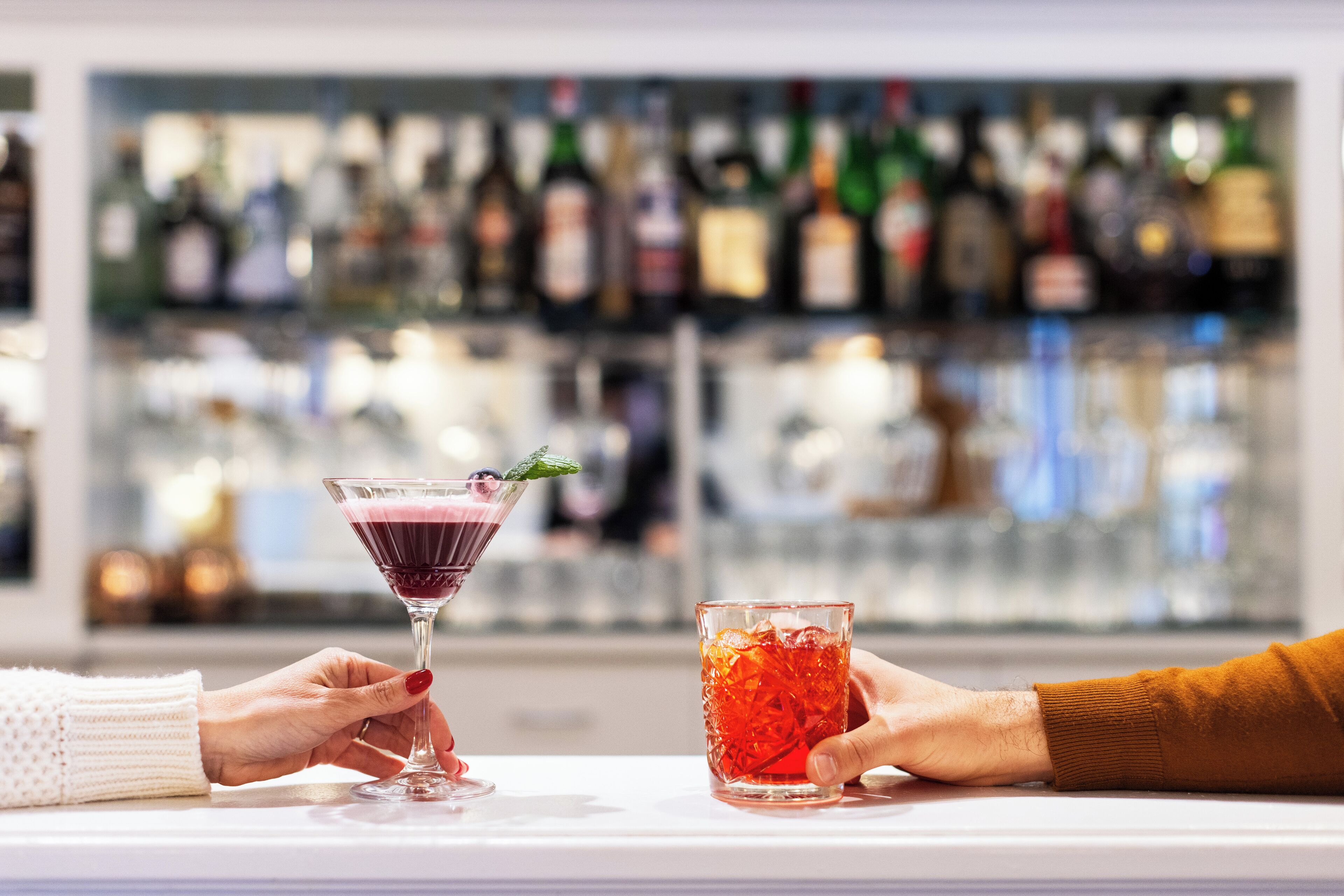 A bar with a variety of bottles in the background.