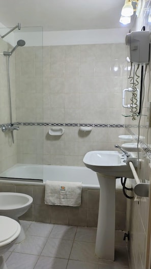 A bathroom with a bathtub, a sink, a toilet, and a shower. - Guarumba Apart Hotel (Federacion)