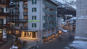 A hotel with multiple floors, balconies, and a snow-covered mountain backdrop. - Cortina (Garda)