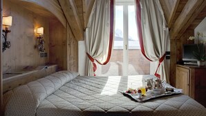 A cozy bedroom with a large bed, a bedside table with a lamp, and a breakfast tray on the bed. - Cortina (Garda)